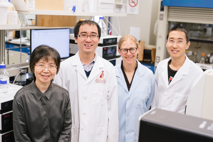 Dr. Leng Chee Chang (left) stands in a laboratory next to three team members