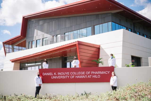 Five pharmacy students stand in front of the DKICP building signage.